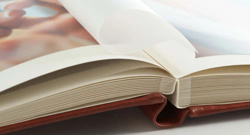 Livro aberto com páginas em branco, destacando qualidade de impressão e encadernação premium.