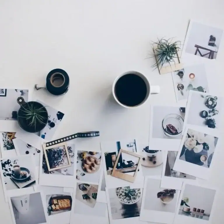 Café preto em caneca branca com fotos de decoração e plantas ao redor, ambiente de trabalho criativo e inspirado.